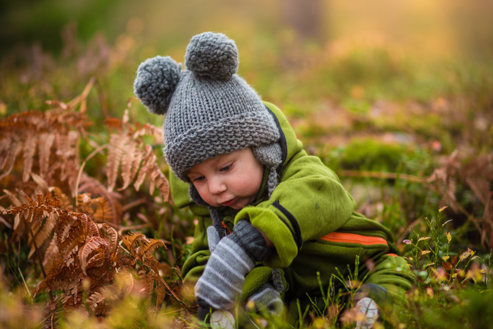 selective focus photo of baby on green grass field